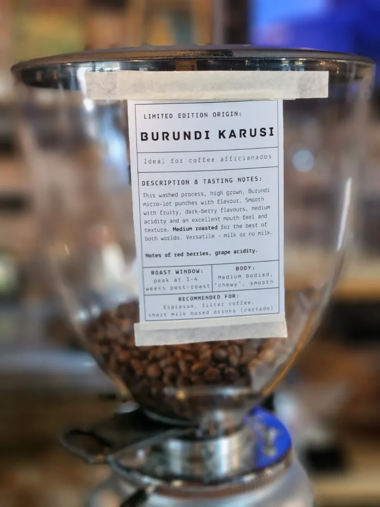 Espresso grinder hopper filled with beans, labelled Limited Edition Origin Burundi Karusi with tasting notes of red berries and grape acidity