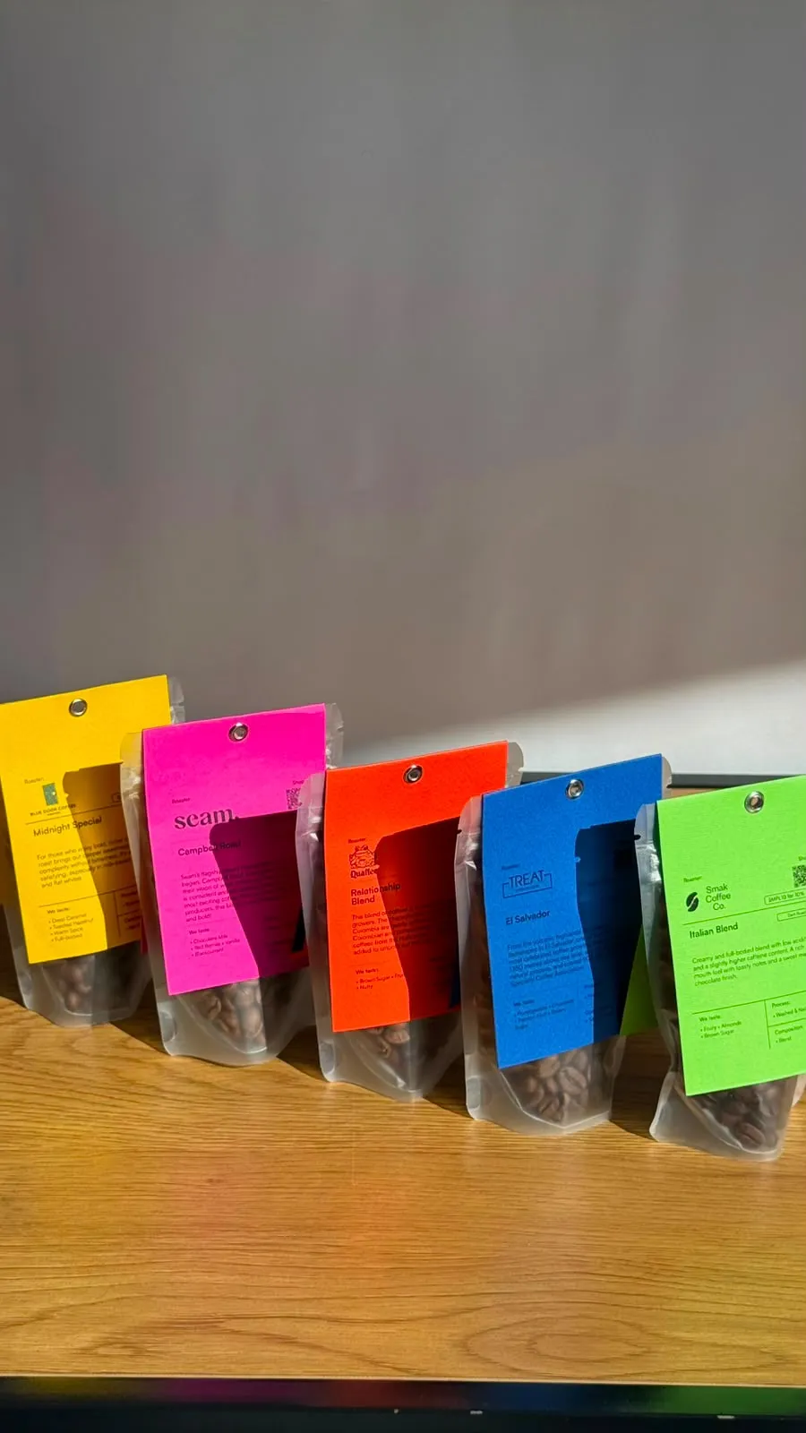 Five colourful specialty coffee bags from different origins at Apothecary Coffee, each printed with its own tasting notes