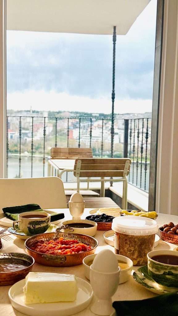 Breakfast spread with coffee on a balcony overlooking the water