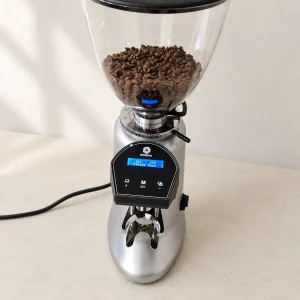 Second-hand Sigma on-demand commercial coffee grinder in grey with beans in the hopper